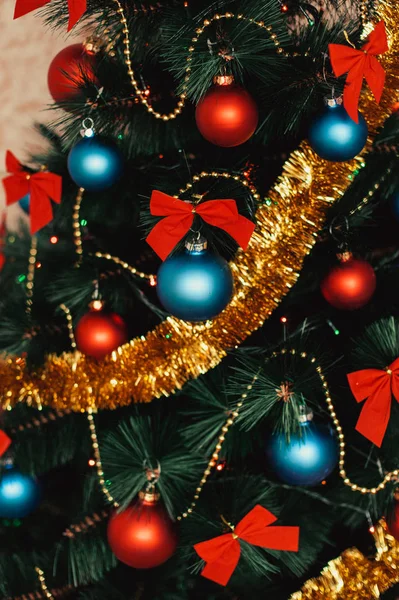 Cerrar adornos de árboles de Navidad de vidrio con bolas de color rojo, azul, oropel dorado, arcos rojos, cordones dorados de cuentas con brillo y cálidos detalles de iluminación. Año Nuevo y vacaciones 2018 concepto . — Foto de Stock