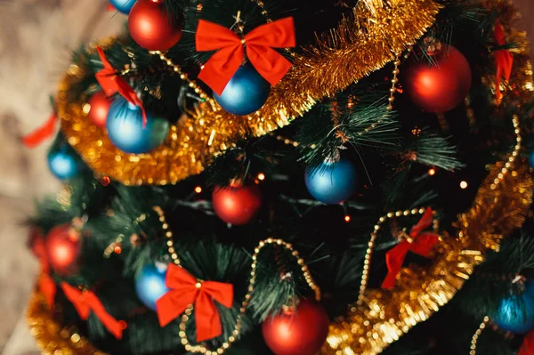 Cerrar adornos de árboles de Navidad de vidrio con bolas de color rojo, azul, oropel dorado, arcos rojos, cordones dorados de cuentas con brillo y cálidos detalles de iluminación. Año Nuevo y vacaciones 2018 concepto . — Foto de Stock