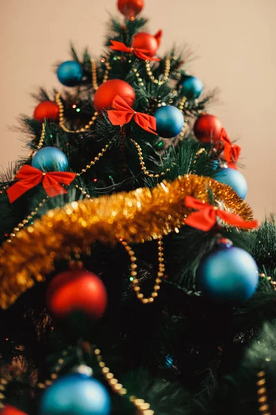 Cerrar adornos de árboles de Navidad de vidrio con bolas de color rojo, azul, oropel dorado, arcos rojos, cordones dorados de cuentas con brillo y cálidos detalles de iluminación. Año Nuevo y vacaciones 2018 concepto . — Foto de Stock