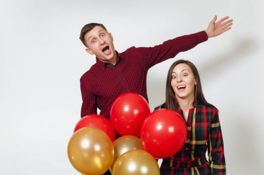 Güzel beyaz genç mutlu crazy eğlenceli çift aşık. Kadın ve adam izole beyaz arka plan üzerinde doğum günü kutlama kırmızı, sarı balonları, ekose kareli giysiler içinde. Tatil, parti konsept