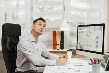 Ciddi ve dalgın iş adamı w masada oturan gömlek