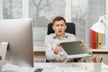 Çapraşık şok ve bilgisayarda çalışan modern monitör, klasörler, lamba, belge penceresi arka plan üzerinde ışık Office ile iş adamı masa başında oturan gömlek stres. Yöneticisi veya alt.