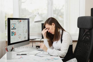 Güzel çapraşık yorgun ve ışık Office belgeleri ile çağdaş bilgisayarda çalışan brown-iş kadın takım elbise ve fincan kahve masa başında oturan gözlük stres