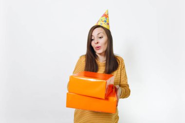 Güzel beyaz eğlenceli kutluyor ve reklam için izole beyaz arka plan üzerinde tatil keyfini mutlu kadın sarı giysili turuncu hediye kutuları ile mevcut, holding doğum günü parti şapkası.