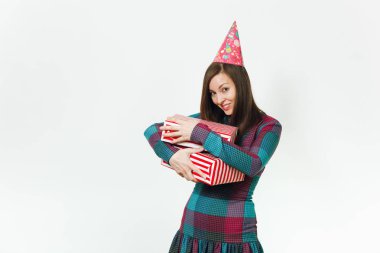 Beyaz eğlence genç gülümseyen güzel ekose elbise ve doğum günü parti şapkası iki hediye ile mutlu kadın mevcut kutuları, kutlama ve reklam için izole beyaz arka plan üzerinde tatil keyfini.