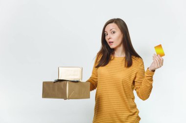 Kredi kartı, nakit para, altın hediye kutuları mevcut, kutluyor tatil partisi ile izole beyaz arka plan üzerinde tutan sarı giysili güzel beyaz üzgün genç kızgın doğum kadın.