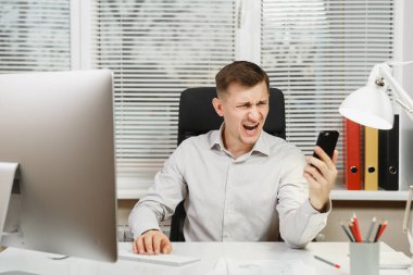 Çalışma ile modern sınıf başkanı bilgisayar, ışık office belgelerinde, sorunlarını, Masa başında oturan gömlek konuşmak, küfür ve üstünde hareket eden telefon, çığlık ciddi kızgın stres iş adamı çözme.