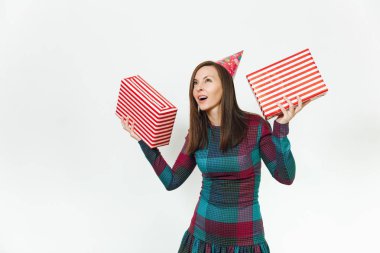 Beyaz eğlence genç gülümseyen güzel ekose elbise ve doğum günü parti şapkası iki hediye ile mutlu kadın mevcut kutuları, kutlama ve reklam için izole beyaz arka plan üzerinde tatil keyfini.