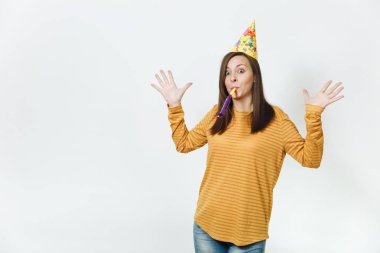 Güzel beyaz eğlenceli boru oynarken, tatil kutluyor, eller için reklam izole beyaz arka plan üzerinde yayılan genç mutlu kadın sarı giysiler ve doğum günü parti şapkası kahverengi uzun saçlı.