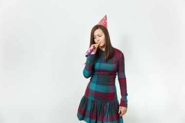 Beyaz arka plan için reklam izole mevcut tatil olmadan kutlayan güzel beyaz üzgün, yalnız ve sıkıntılı genç kadın mavi ekose elbise ve doğum günü parti şapkası ile boru,.
