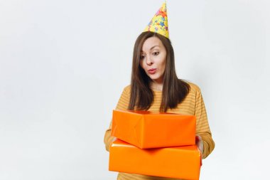 Güzel beyaz eğlenceli kutluyor ve reklam için izole beyaz arka plan üzerinde tatil keyfini mutlu kadın sarı giysili turuncu hediye kutuları ile mevcut, holding doğum günü parti şapkası.