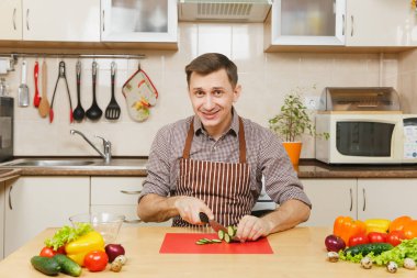 Gülümseyen beyaz yakışıklı genç bir önlük kahverengi gömlek si