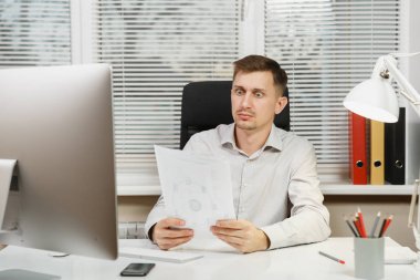 Çapraşık şok ve bilgisayarda çalışan modern monitör, klasörler, lamba, belge penceresi arka plan üzerinde ışık Office ile iş adamı masa başında oturan gömlek stres. Yöneticisi veya alt.