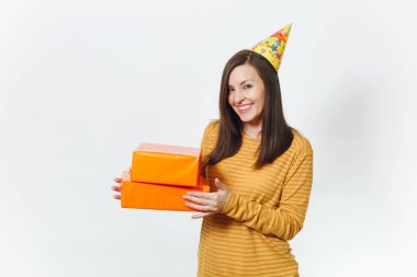 Güzel beyaz eğlenceli kutluyor ve reklam için izole beyaz arka plan üzerinde tatil keyfini mutlu kadın sarı giysili turuncu hediye kutuları ile mevcut, holding doğum günü parti şapkası.
