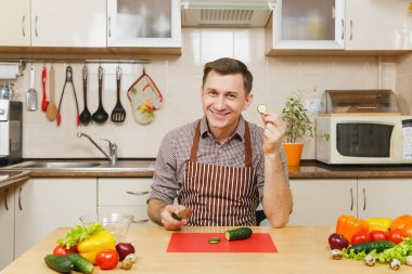 Gülümseyen beyaz yakışıklı genç bir önlük kahverengi gömlek si