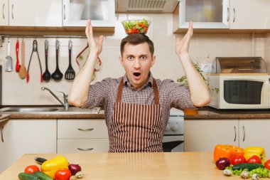 Çekici eğlenceli önlük, beyaz genç adam kahverengi gömlek oturma