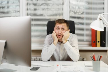 Çapraşık şok ve bilgisayarda çalışan modern monitör, klasörler, lamba, belge penceresi arka plan üzerinde ışık Office ile iş adamı masa başında oturan gömlek stres. Yöneticisi veya alt.