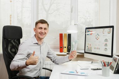 Yakışıklı gülümseyen iş adamı ile masada oturan gömlek 