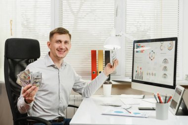 Yakışıklı gülümseyen iş adamı ile masada oturan gömlek 