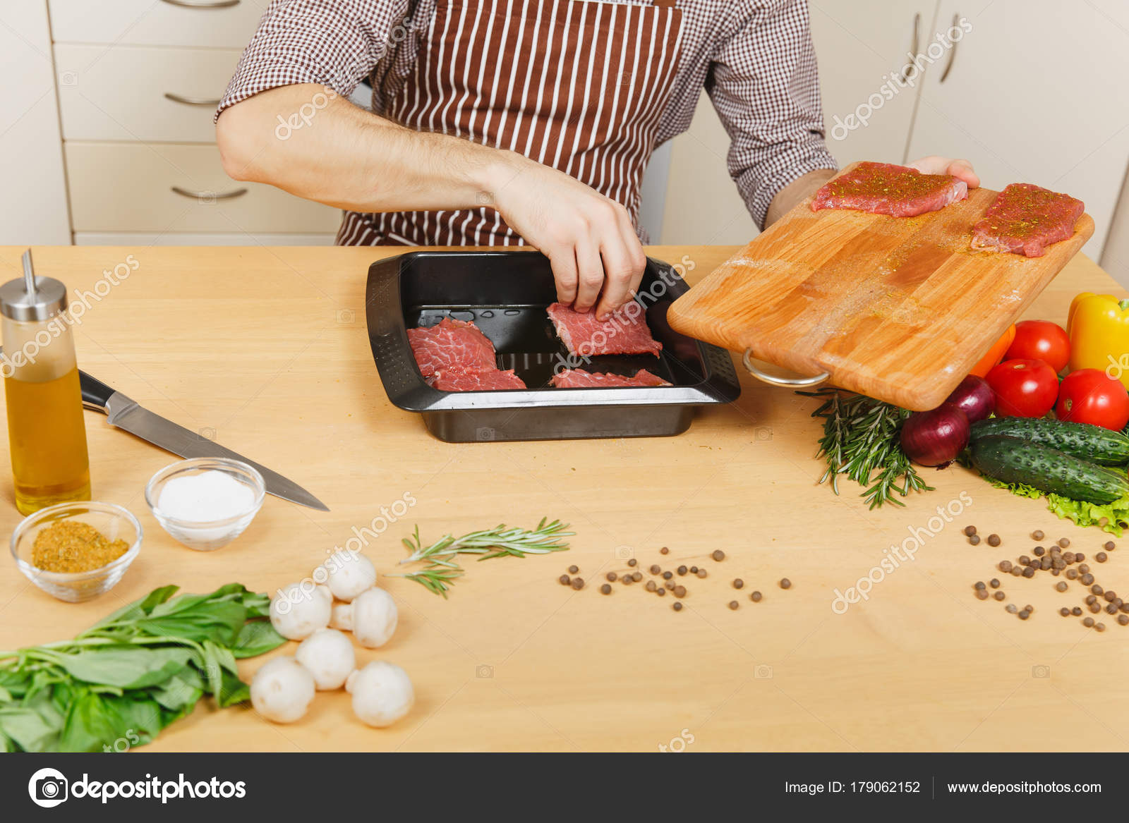 Junger Mann in Schürze mit Gemüse, am Tisch sitzen zu Hause kochen ... Junger Mann in Schürze mit Gemüse, am Tisch sitzen zu Hause kochen ...