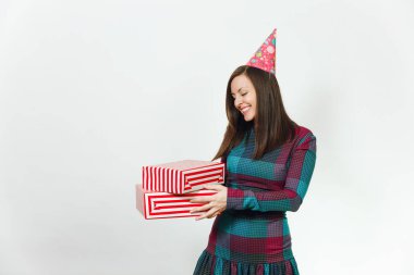 Beyaz eğlence genç gülümseyen güzel ekose elbise ve doğum günü parti şapkası iki hediye ile mutlu kadın mevcut kutuları, kutlama ve reklam için izole beyaz arka plan üzerinde tatil keyfini.