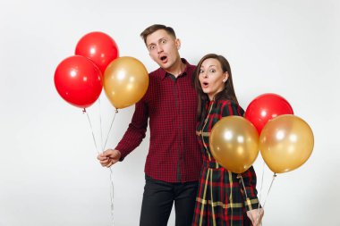 Güzel genç mutlu gülümseyen çift aşık. Kadın ve adam izole beyaz arka plan üzerinde doğum günü kutlama kırmızı, sarı balonları, ekose kareli giysiler içinde. Tatil, parti konsept.