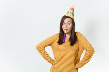 Güzel beyaz eğlence genç mutlu kadın kutluyor ve reklam için izole beyaz arka plan üzerinde tatil keyfini boru, oynayan sarı giysiler ve doğum günü parti şapkası kahverengi uzun saçlı.