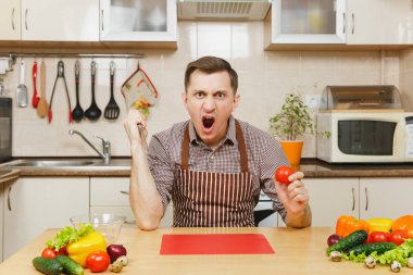 Öfkeli deli beyaz genç adam, oturmak önlük, kahverengi gömlekli