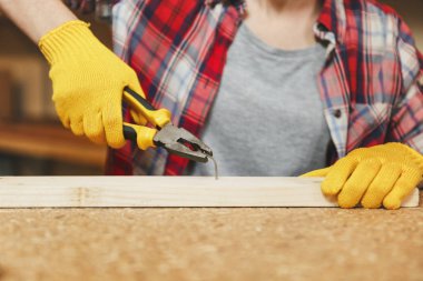 Ekose gömlekli, gri T-shirt, sarı eldiven genç kadın kapatmak