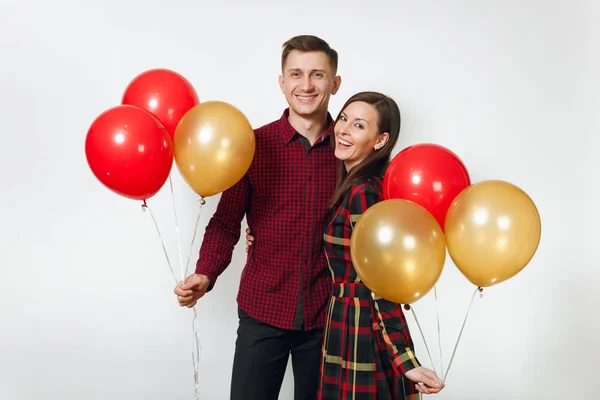 Hermosa caucásica joven feliz sonriente pareja en el amor. Mujer y hombre en ropa a cuadros a cuadros con globos rojos, amarillos, celebrando cumpleaños, sobre fondo blanco aislado. Vacaciones, concepto de fiesta . —  Fotos de Stock