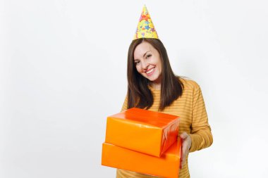 Güzel beyaz eğlenceli kutluyor ve reklam için izole beyaz arka plan üzerinde tatil keyfini mutlu kadın sarı giysili turuncu hediye kutuları ile mevcut, holding doğum günü parti şapkası.