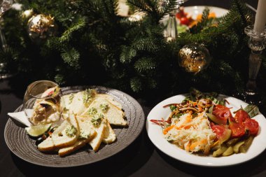 Koyu siyah masa örtüsü tablo üzerinde gri ve beyaz tabak portre restoran yemek yemek için rahat lüks restoranda. Mükemmel bir sebze, peynir, atıştırmalıklar, havyar. Kavram yemek.