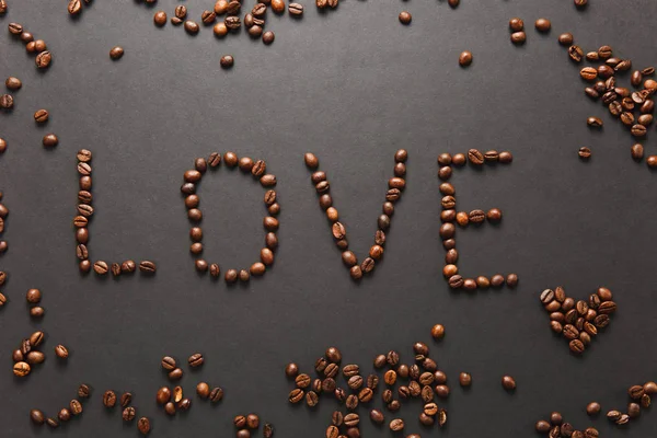 Вид сверху буквы любви, слово, сделанное из кофейных бобов на черном ба — стоковое фото