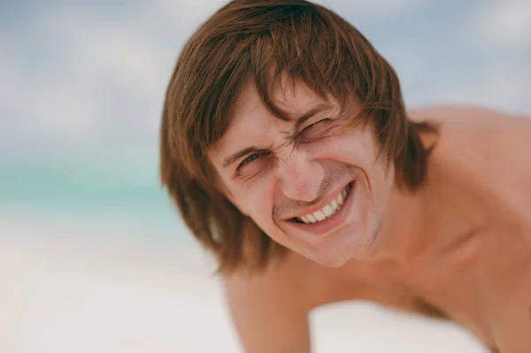 Jóképű férfi, hosszú haj, mosolyogva a strandon — Stock Fotó