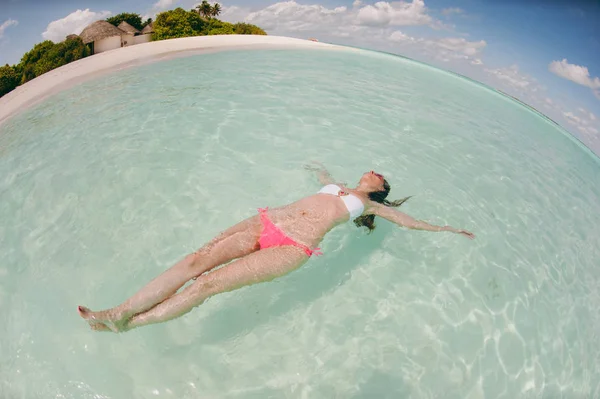 Hermosa chica se encuentra en el agua en el océano — Foto de Stock