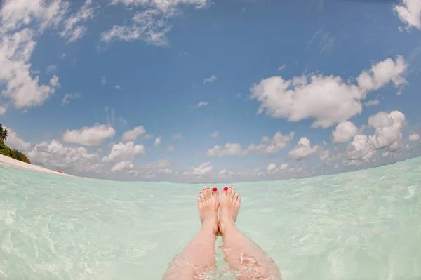 Piedi di una donna in un oceano trasparente — Foto Stock