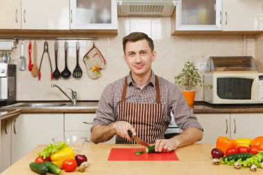 Gülümseyen beyaz yakışıklı genç bir önlük kahverengi gömlek si