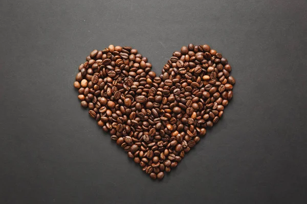 Кофейные зерна в форме сердца изолированы на черной текстуре ба — стоковое фото