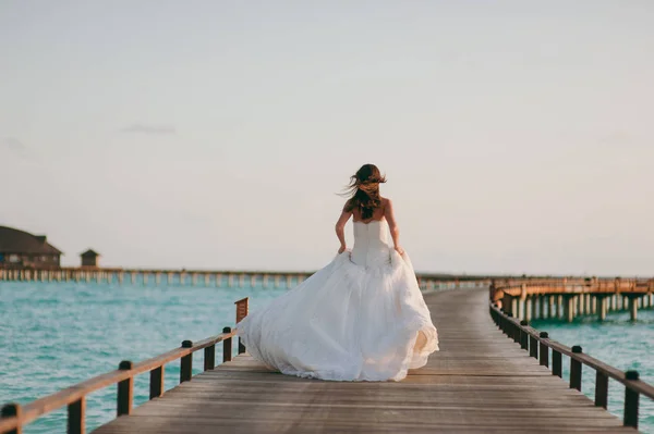 Beautiful bride on a pier near water bungalows — Stock Photo, Image