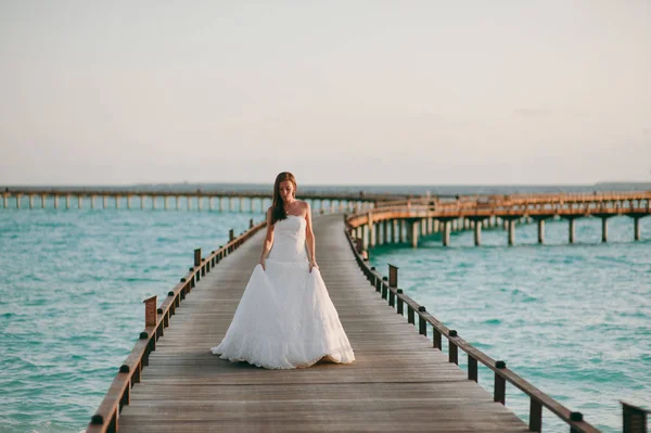 Beautiful bride on a pier near water bungalows — Stock Photo, Image