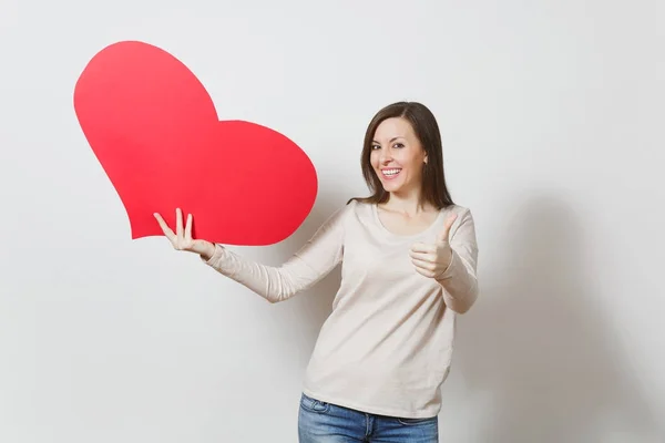 Hermosa joven sonriente mujer sosteniendo gran corazón rojo, mostrando thu — Foto de Stock