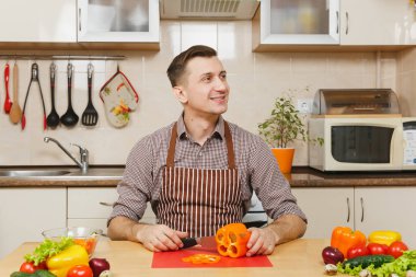 Gülümseyen beyaz yakışıklı genç bir önlük kahverengi gömlek si