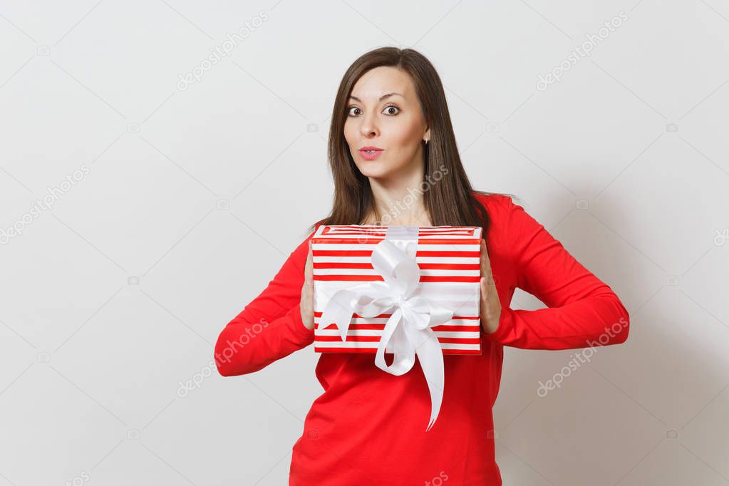 Smiling woman holding red striped present box with ribbon, bow isolated on white background. For advertisement. St. Valentine's Day, International Women's Day, Christmas, birthday, holiday concept.