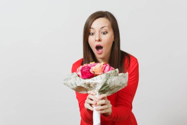 Beyaz zemin üzerine kırmızı giysili güzel gül buket tutan genç gülümseyen kadın izole. Reklam için yer kopyalayın. Sevgililer günü veya Dünya Kadınlar Günü kavramı.