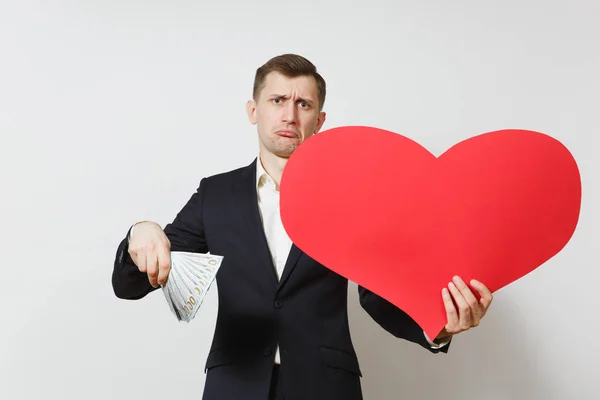 Hombre insatisfecho con gran corazón rojo, paquete de dinero en efectivo dólares aislados sobre fondo blanco. Copia espacio para la publicidad. Día de San Valentín, Día Internacional de la Mujer, concepto de fiesta de cumpleaños . — Foto de Stock