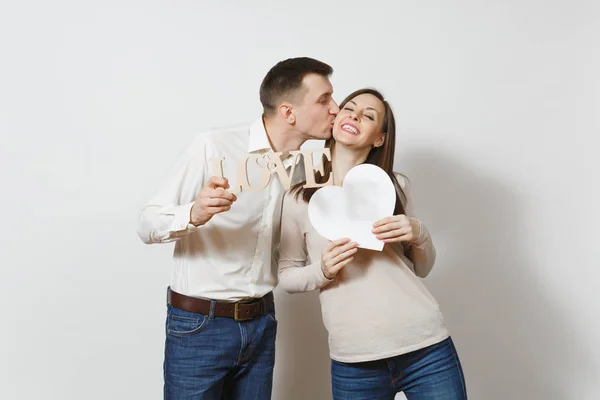 Kissing couple. Man, woman with word Love, big white heart isolated on white background. For advertisement. With place for text. St. Valentine's Day, International Women's Day birthday holiday concept — Stock Photo, Image