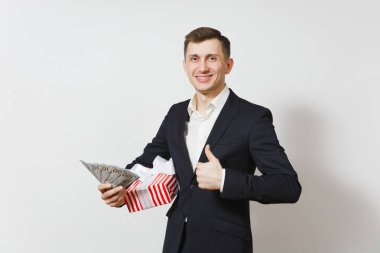 Kırmızı mevcut kutu hediye, bohça-in nakit para ile beyaz arka plan üzerinde izole dolar tutan takım elbiseli genç yakışıklı adam. Sevgililer günü, Dünya Kadınlar Günü, doğum günü tatil kavramı.