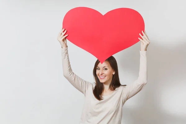 Attraktive junge lächelnde Frau hält großes rotes Herz in den Händen — Stockfoto