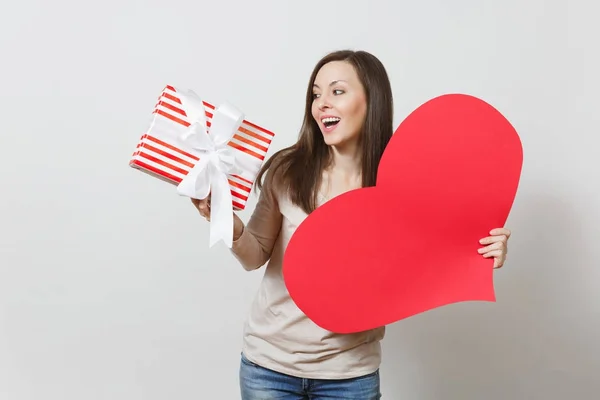 Schöne junge lächelnde Frau mit großem roten Herz, Schachtel mit Geschenk auf weißem Hintergrund. Kopierfläche für Werbung. mit Platz für Text. St. Valentinstag oder Internationaler Frauentag. — Stockfoto