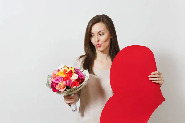 Skeptische Frau mit großem roten Herz, Strauß schöner Rosenblüten auf weißem Hintergrund. Kopierfläche für Werbung. Platz für Text. St. Valentinstag oder Internationaler Frauentag. — Stockfoto